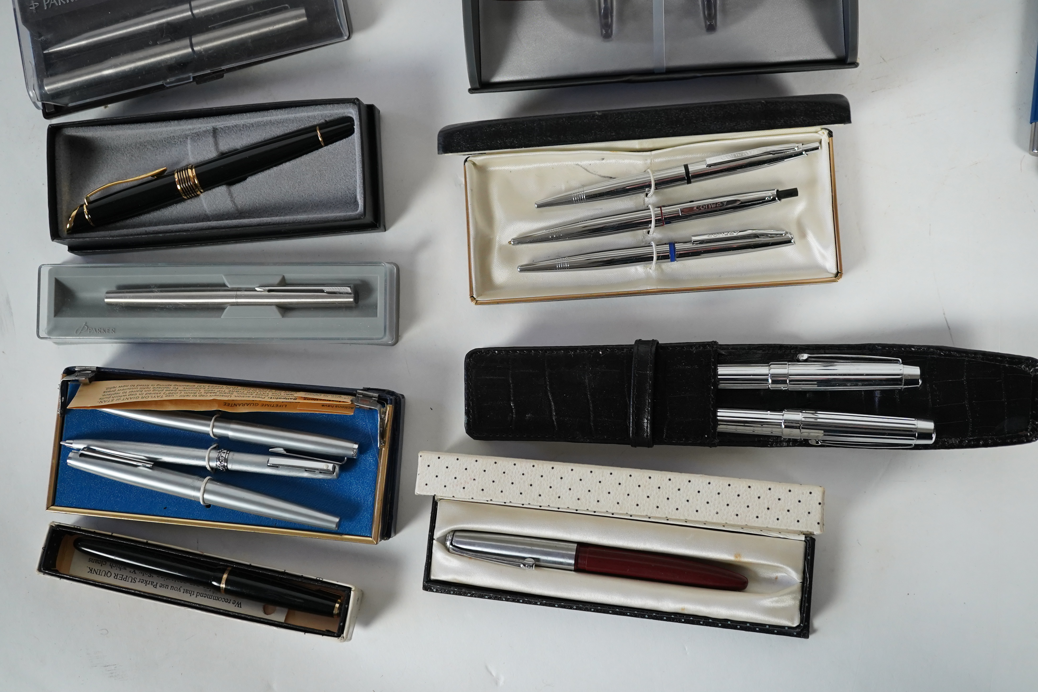 A cased Parker duofold ballpoint pen, a cased Parker Sonnet lacquer ruby red fountain pen, a Dunhill gold plated fountain pen and various fountain pens and ballpoint pens including Parker, Sheaffer, Quill, etc.